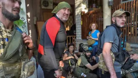 Reuters Rescuers react to Russian shelling during evacuation efforts of those trapped by flooding in Kherson region