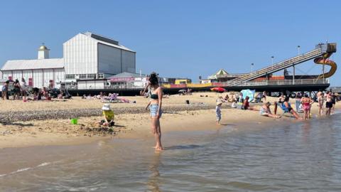 Great Yamouth's beach and Britannia Pier with bathers paddling on the shore