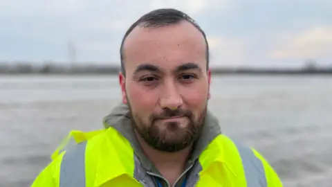 BBC Ilhomjon is wearing a green reflective jacket 