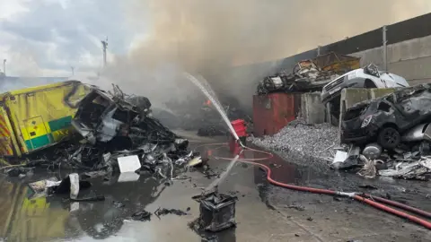 GMCA Una antigua ambulancia y los autos se cuestionan después de ser quemado en el incendio