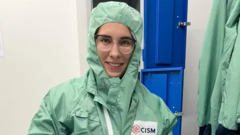 16 year old Kateryna wears pale green protective clothing which also covers her hair