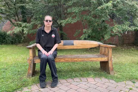 Val Collins on a bench