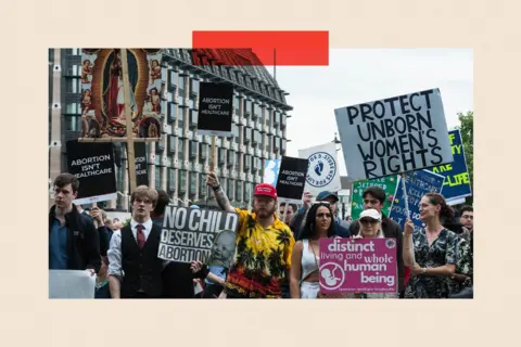 Getty Protesters stand in a square, holding placards