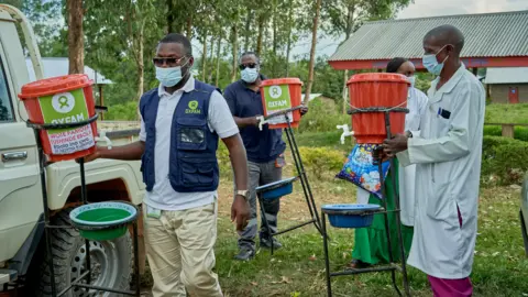 Azaria Muhongya / Oxfam Three Oxfam workers and a nurse pictured during a handwashing kits delivery at Shari Health Centre in DR Congo.
