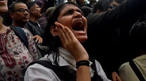 A crowd gathered at Delhi's Jantar Mantar in solidarity with the Cockroach Janata Party, demanding educational reforms and India's education minister Dharmendra Pradhan's resignation on 22 July. A woman protester wearing a white shirt participates in sloganeering.