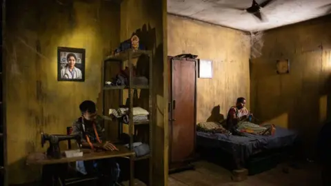 Swastik Pal A tableau recreates the bereaved family of the doctor whose portrait hangs on the wall at a Puja