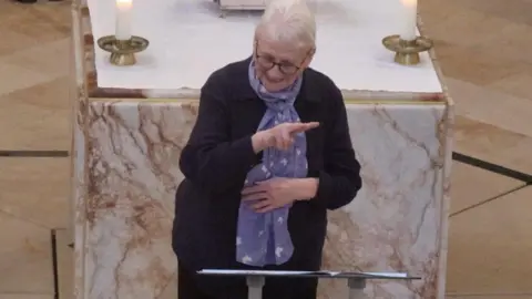 Anne Lawrence using British Sign Language while signing at Leicester Cathedral
