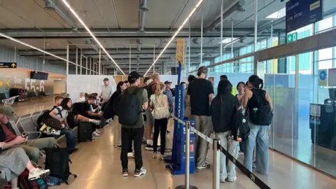 A huddle of people arguing with airport staff