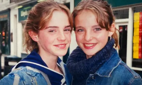 Flick Miles Emma Watson and Flick Miles smiling in blue jackets 