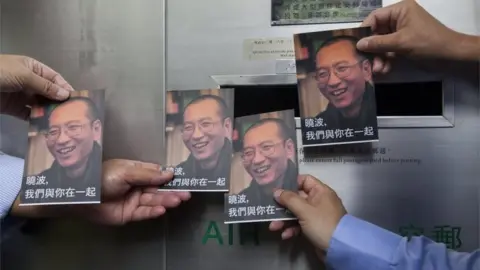 EPA Activists from the Hong Kong Alliance in Support of Patriotic Democratic Movements of China hold some of the one thousand postcards containing messages of support to be sent from the public to Chinese dissident Liu Xiaobo, at the General Post Office, Central District, Hong Kong, China, 05 July 2017.