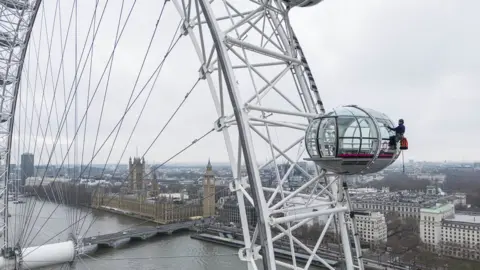 Jake Mobbs A window cleaner scrubs the London Eye pods