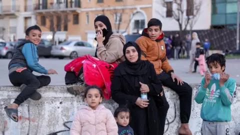 Reuters A displaced woman and children in Martyrs' Square, central Beirut (5 March 2026)