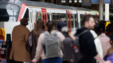 People with luggage on platform at a railway station.