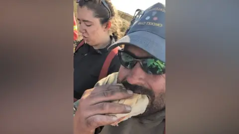 Micklehurst Cricket Club Firefighter tucks into a ham sandwich