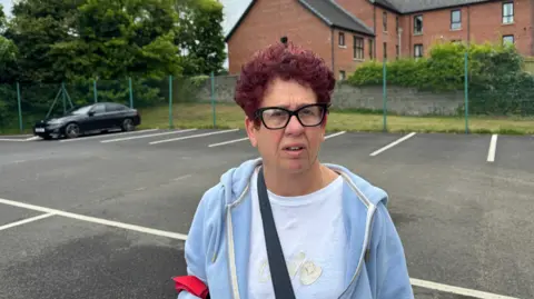 Vilma has red curly hair, a blue hoody and white tshirt