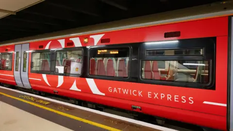 A bright red train at a station. 