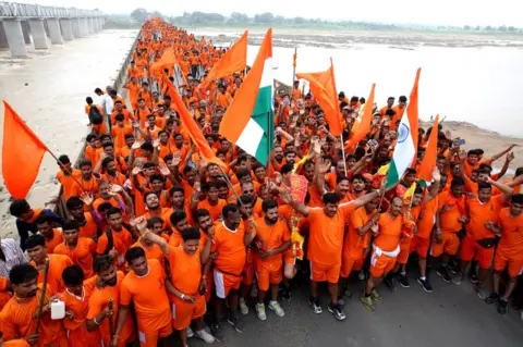 EPA Kanwariyas gather after collecting water from the river Narmada during their annual pilgrimage on 4 August 2018.