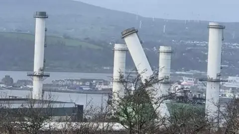 Maxine Johnston Ballylumford powerfulness  presumption     - achromatic  chimneys, 1  is visibly damaged and bent, dwellings and mountains disposable   successful  background