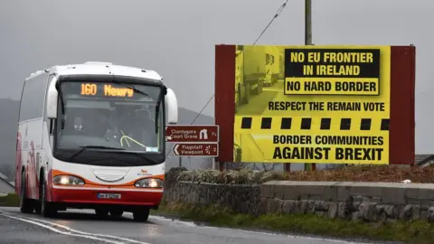 Getty Images A coach passes a campaign sign rejecting a hard border in Ireland