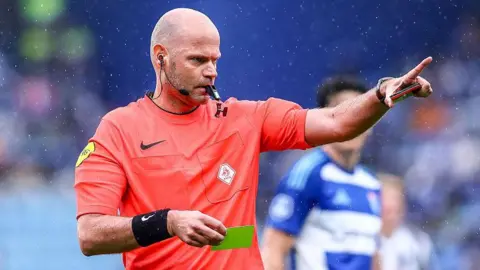 Rob Dieperink holds a yellow card