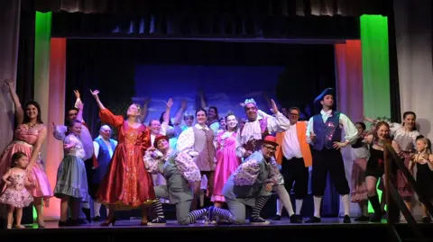 The colourful cast of the panto in position at the end of a musical number.
