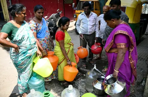 Getty Images Locals gather to fill cans of water from a municipal tap, amid an ongoing water crisis in Bengaluru on March 7, 2024