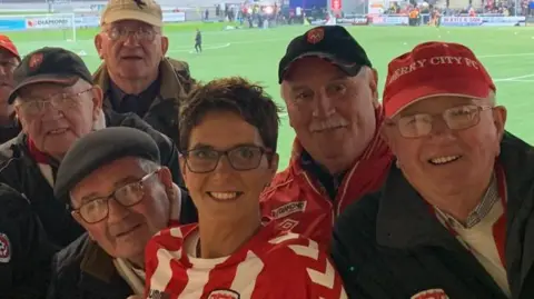Carmel McConnellogue Carmel McConnellogue pictured with members of the pride of the Northside supporters' club at Derry City 