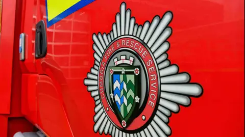A Cumbria fire and rescue service logo pictured on the side of a red fire engine.