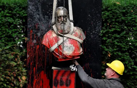 JOHN THYS/AFP A man removes a vandalised statue of King Leopold II of Belgium