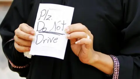 Reuters Female driver Azza al-Shmasani displays a note, which according to her, was placed on her car by an unknown person, in Saudi Arabia (22 June 2011`)