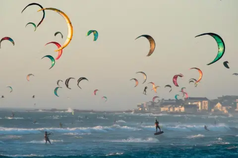 AFP Kite surfers kitesurf in good wind and weather on February 6, 2019, in Tableview, about 15km from the centre of Cape Town.