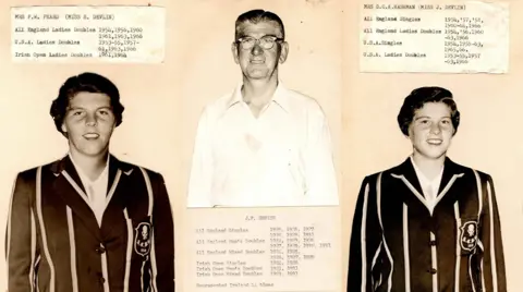 Pamela Peard A discoloured browning scan depicts three people. On the left is Pam's mother, who has short wavy hair, wearing a black blazer with white stripes. On it is a crest representing her club. In the middle is Pam's grandfather, with shorn greying hair and heavy lensed glasses, wearing a white open collar shirt. To the right is her aunt, Who is dressed and looks similar Pam's mother, only younger. Each is depicted alongside their many championship wins.