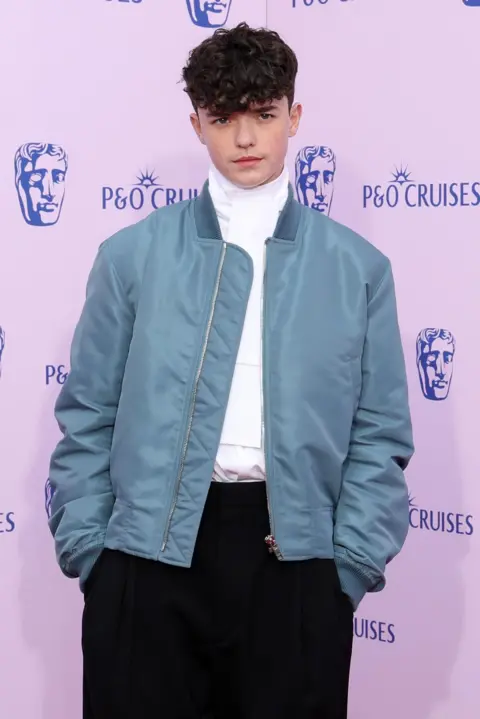 Getty Images Owen Cooper in a blue casual jacket, white shirt and dark trousers