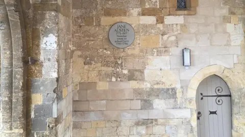 Reading Borough Council A grey plaque commemorating Jane Austen on a stone wall