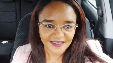 Twasul Mohammed Twasul Mohammed. She has long brown hair, wearing glasses and a pink blazer.