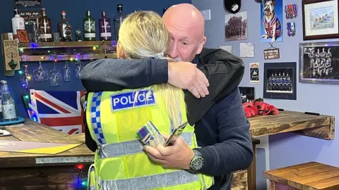 Mr Eamer hugging the policewoman who returned the medals