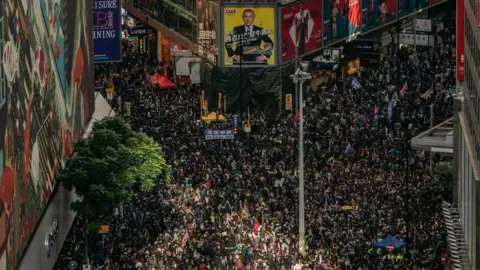 Getty Images Pro-democracy protesters march on a street as they take part in a demonstration on December 8, 2019 in Hong Kong,
