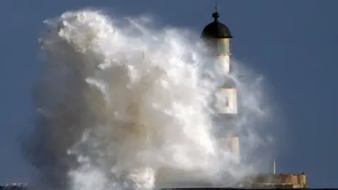 PA Media The lighthouse at Seaham in Durham in stormy weather