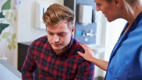 Getty Images Nurse reassuring a male patient