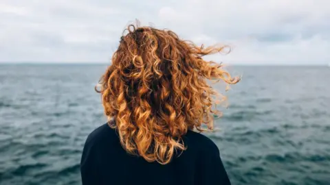 Getty Images A woman from looking out over the sea