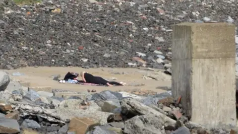 Tristam Evans Woman sunbathing on beach