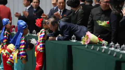 Reuters/Pyongyang Press Corps Moon Jae-in talks to a small North Korean child