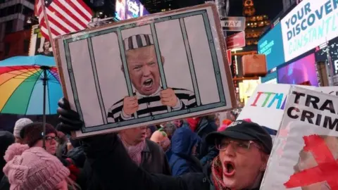 Getty Images Protesters in favour of President Trump's impeachment gather in New York's Times Square on Tuesday