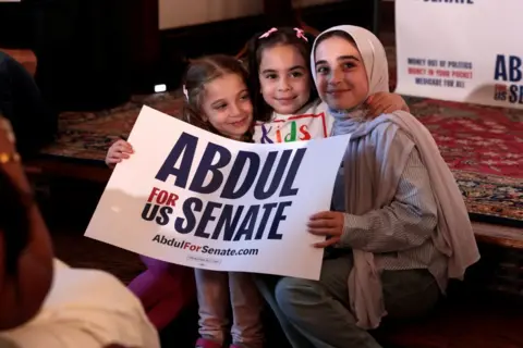 Getty Images Three young girls hold a sign saying "Abdul for US Senate" in support of the Democratic Senate candidate 