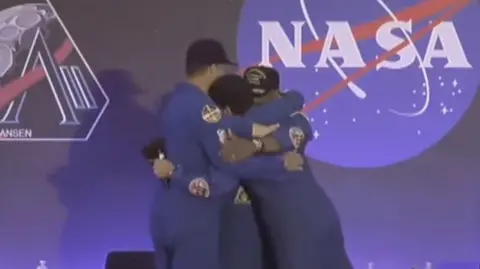 Artemis crew hug on stage in Houston 