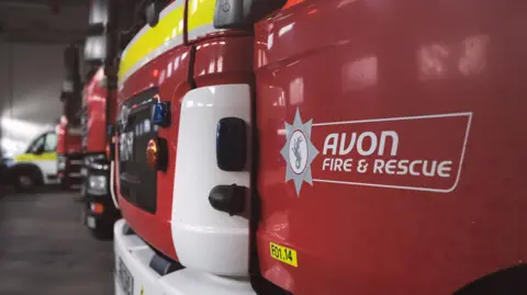 Avon Fire and Rescue Service A close-up of the front bumper of a fire service appliance, with Avon Fire & Rescue written on the open door at the front.