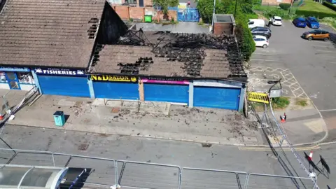 supplied A drone shot above shops, three of which have been burnt out.