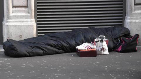 Person sleeping on pavement
