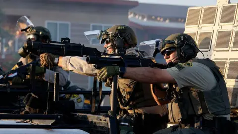 Los Angeles County Sheriff officers fire flash bang grenades at protesters
