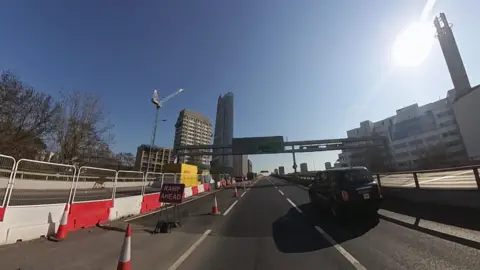 A black cab travels along the A40